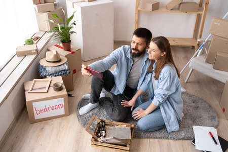 New home move concept, young couple taking selfie in new apartment, family relocation to light house, life moments man and woman with smartphone, memoryの写真素材