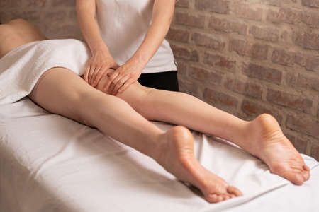 Anti-cellulite massage in the spa salon. Slimming and body shaping. masseur massages the thigh and legs. Healthy body and skin.の写真素材