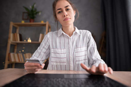 Hispanic woman holding a credit card and using laptop for online shopping, webcam viewの写真素材