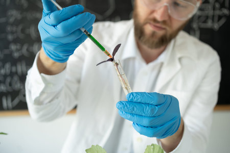 Male microbiologist in safety glasses adding biological nutritional supplement vitamins from a...
