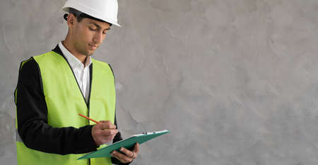 Serious Arab engineer taking note on clipboard, bannerの写真素材