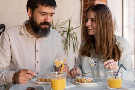 Happy couple having breakfast together in the kitchenの写真素材