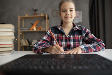 Portrait of smiling girl studying at online school, student attending distant course using laptop pc, web-based education, remote communication. webcam viewの写真素材