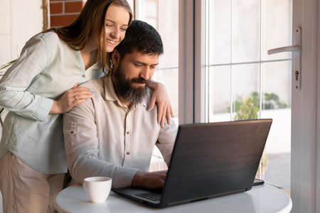 Happy young couple with laptop at homeの写真素材