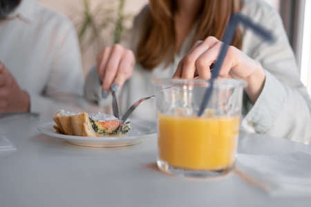 close up of couple having breakfast with fresh juice at home. people and healthy foodの写真素材