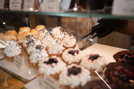 Delicious cake with white butter cream, nuts.Sweet chocolate dessert on showcase display in a cafe.Handmade homemade cakes.A pastry shop with cakes. Small business restaurant foodの写真素材