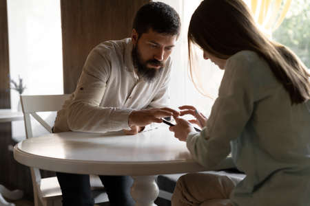 Happy couple using smartphone together in cafe, flirtingの写真素材