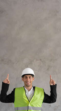 Handsome arabic man wearing safety helmet and reflective jacket smiling with an idea pointing fingers up with happy face, number two, bannerの写真素材
