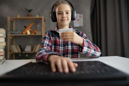 Online shopping. girl child holding credit card and using laptop at home. schoolgirl working on computer at home, webcam view, POV. Business, e-commerce, internet banking, freelanceの写真素材