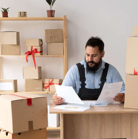 Starting small business, SME owner man entrepreneur prepare to pack the boxes track deliveries and invoices, sell to customers, sme business ideasの写真素材