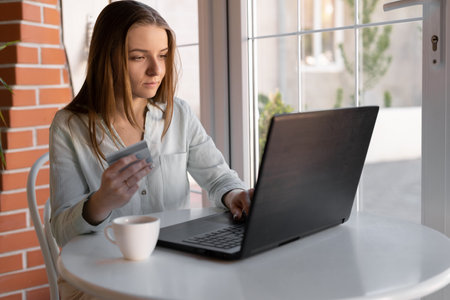 Online payment by credit card, young woman using laptop computer spending money for online shopping, internet banking, people and digital technology, e commerce businessの写真素材