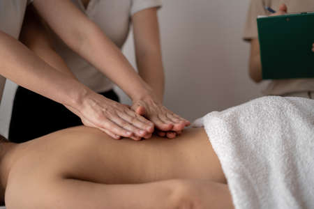 Massage courses, training of massage therapists, teacher helps student to do wellness massageの写真素材