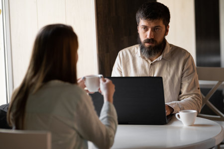 Man and woman working with computer in cafe, informal meeting in coffee shop using laptop, copy spaceの写真素材