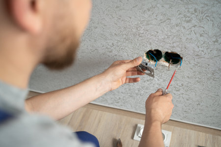 electrician connects the sockets to the electrical wires on the wall, work on installing outlets.の写真素材
