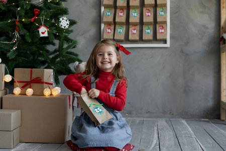 Happy child with handmade advent calendar gift package with candy, Christmas childrens fanの写真素材