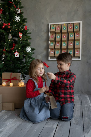 Happy kids with christmas advent calendar craft packs, brother and sister joy from candy pack. Christmas kids fanの写真素材