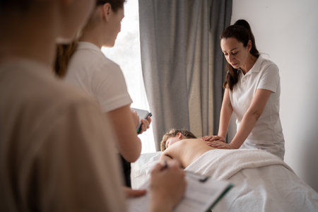 Woman teacher helping student training to become masseuse, health wellness massage trainingの写真素材