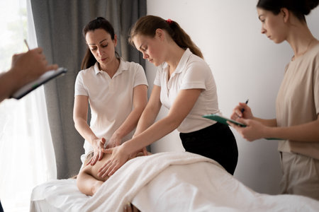 Woman teacher helping students become a masseuse, wellness massage trainingの写真素材