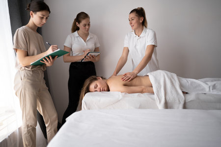 Massage training concept. Teacher helps students become masseuses. Wellness massage trainingの写真素材