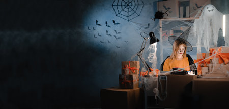 Dropshipping owner in Halloween makeup and witch costume reviewing paper sales report. Entrepreneur woman working at home office. Online marketing, discounts and promotions. Banner.の写真素材