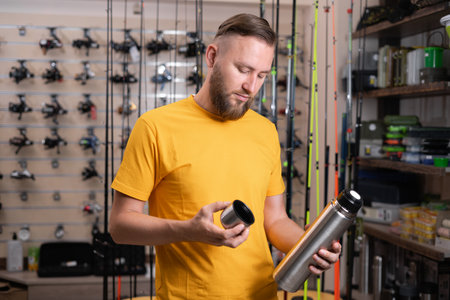 man choosing a thermal bootle in a sports store.の写真素材