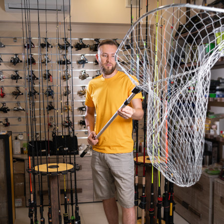 Man chooses a landing net in the sports shop.の写真素材
