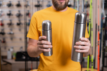 Choosing thermal bottle in a store, person choosing a thermal bottle in a fishing shopの写真素材