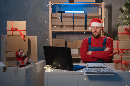 Small business aspiring entrepreneur, SME freelance worker working in a home office man in Santa Claus hat and accepts an online order using an application and a laptop, Christmas saleの写真素材