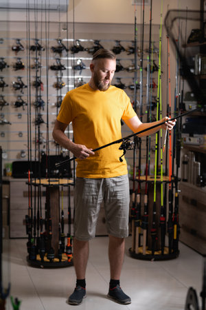 Man chooses fishing rod in the sports shopの写真素材