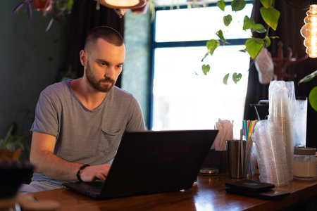 Small business owner working at his cafe using laptop computer.の写真素材