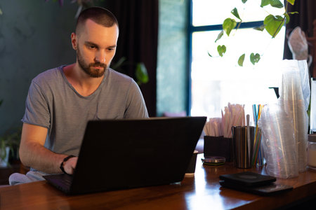 Small business owner working at his cafe using laptop computer.の写真素材