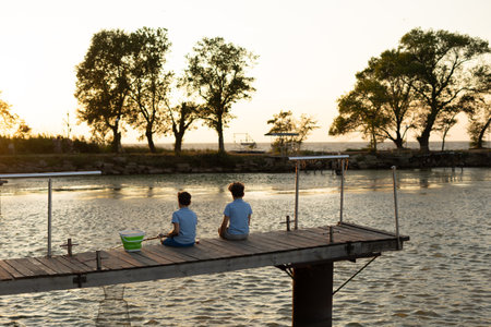 Little boys is fishing at sunset on the lake. Summer leisureの写真素材