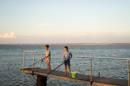 Little boys is fishing at sunset on the lake. Summer hobby and leisureの写真素材