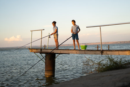 Little boys is fishing at sunset on the lake. Summer hobby and leisureの写真素材