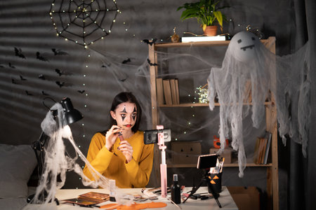 Portrait of young asian woman vlog review gift product fan record video makeup halloween lipstick cosmetics at home in the evening, online influencer social media market live vapingの写真素材