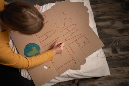 Teen girl making placard for protest for save planet. copy spaceの写真素材
