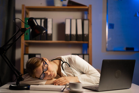 Attractive doctor sleeping on table during night shift. copy spaceの写真素材