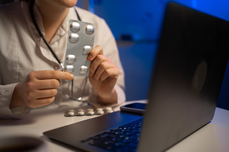 doctor writes a prescription pill on the laptop computer. copy spaceの写真素材