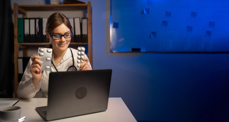 Female doctor advice pills to her patient online in medical office working at night. copyspace. Bannerの写真素材