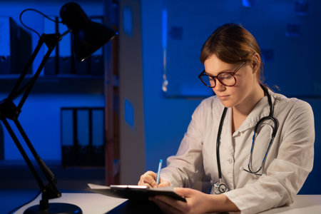 Woman doctor working and making note information of patient in checklist paper on clipboard in medical room of hospital. health care concept. copy spaceの写真素材
