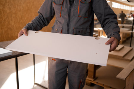 carpenter holding door for kitchen furniture from mdf panel while standing in his workshop.Copy spaceの写真素材