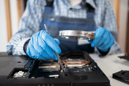 Female engineer repairing and upgrading laptop computer in service center. Worker with tools....