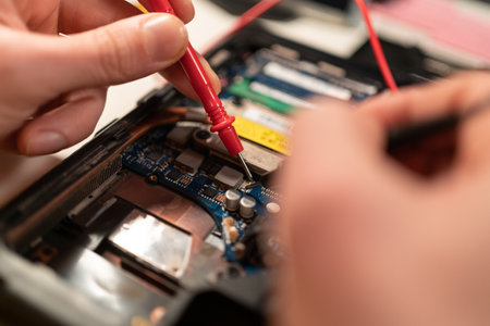 Close up of male hands testing laptop motherboard using multimeter. copy spaceの写真素材