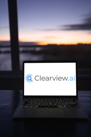 Ukraine, Odessa, February 15, 2023: a laptop is on the table in the morning at dawn near a large window. Clearview AI neural network for face recognition. Artificial interaction for tracking.のeditorial素材