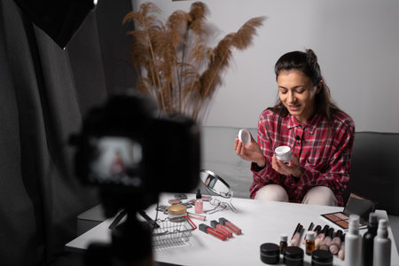 Beautiful hispanic woman blogger is showing how to use cosmetics and to make up. To record vlog video live streaming at home in front of camera. Business online influencer on social media concept.の写真素材