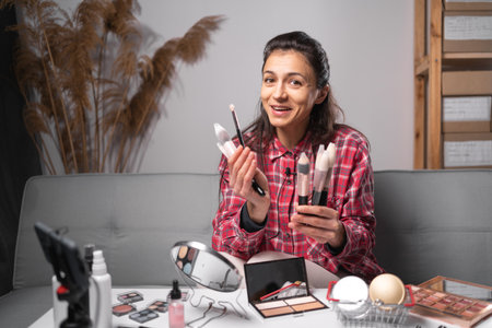 Young hispanic woman professional beauty make up artist vlogger or blogger recording makeup tutorial to share on website or social media recording beauty vlog video live streaming at home. copy spaceの写真素材