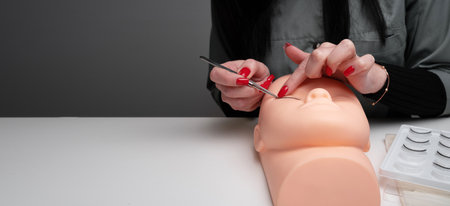 Training eyelash extensions concept. Work on extensions of eyelashes on a mannequin. banner, copy spaceの写真素材