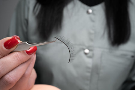 Eyelash extension tools. Accessories for eyelash extensions. Artificial lashes in female hand. Eyelash extension training. close upの写真素材