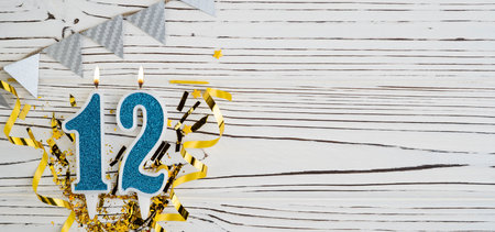 Number 12 blue celebration candle on white wooden background. happy birthday candles. Concept of celebrating birthday, anniversary, important date, holiday. copyspace. Bannerの写真素材