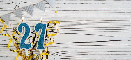 Number 27 blue celebration candle on white wooden background. happy birthday candles. Concept of celebrating birthday, anniversary, important date, holiday. copyspace. Bannerの写真素材